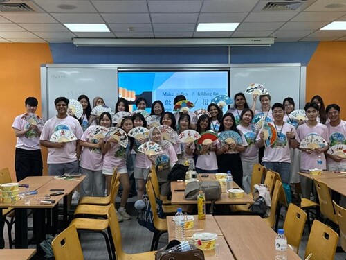 Students engaging in a Mandarin class activity: hand-painting traditional paper fans.(Open new window/jpg file)Image