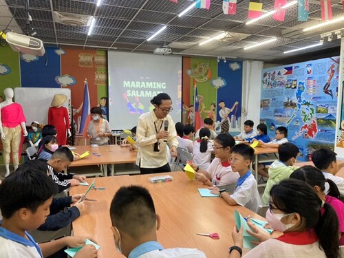 A Filipino international student guides the children in making colorful “Banderitas” garlands, offering a hands-on experience of Filipino festive traditions.(Open new window/jpg file)Image